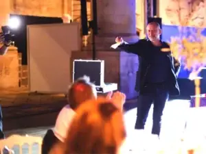 Magicien professionnel en spectacle sur scène devant un public, lors d’une performance de close-up.