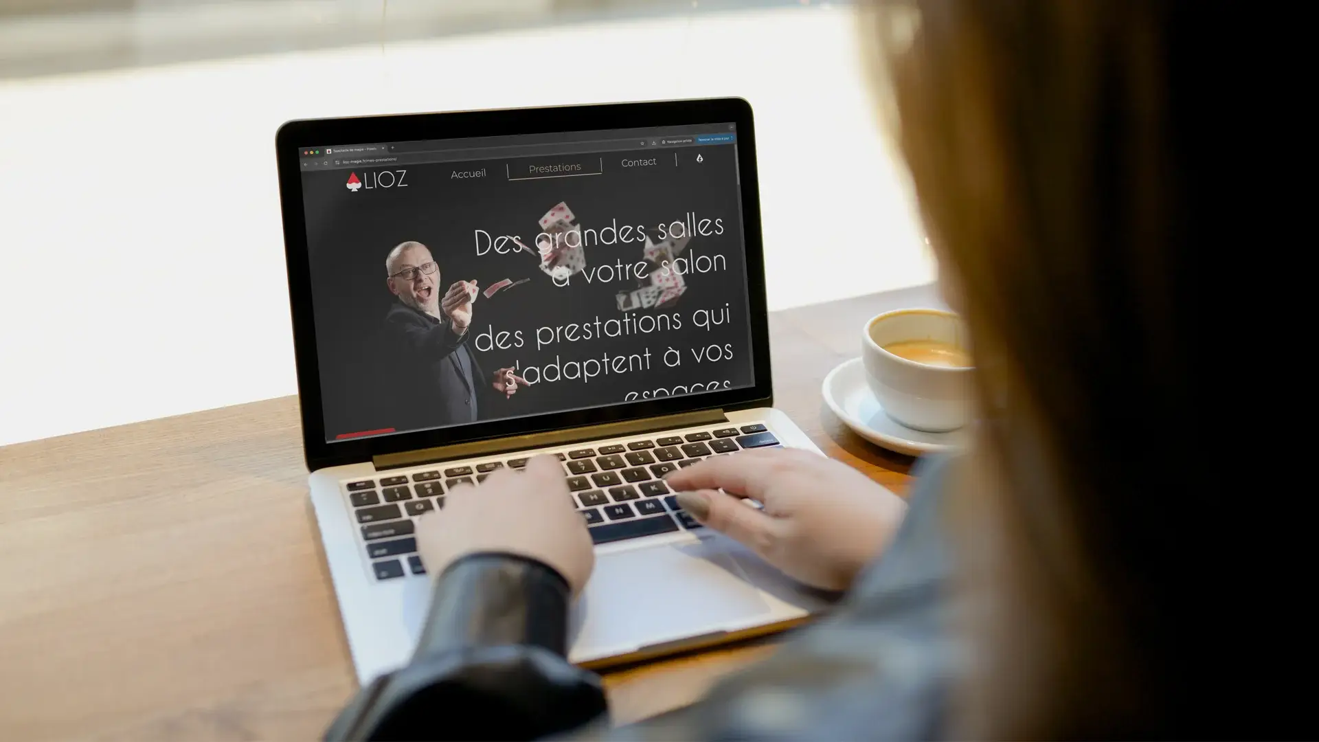 Vue du site internet de Lioz le magicien sur ordinateur portable, affichant la page d’accueil avec une photo de magie en fond sombre.