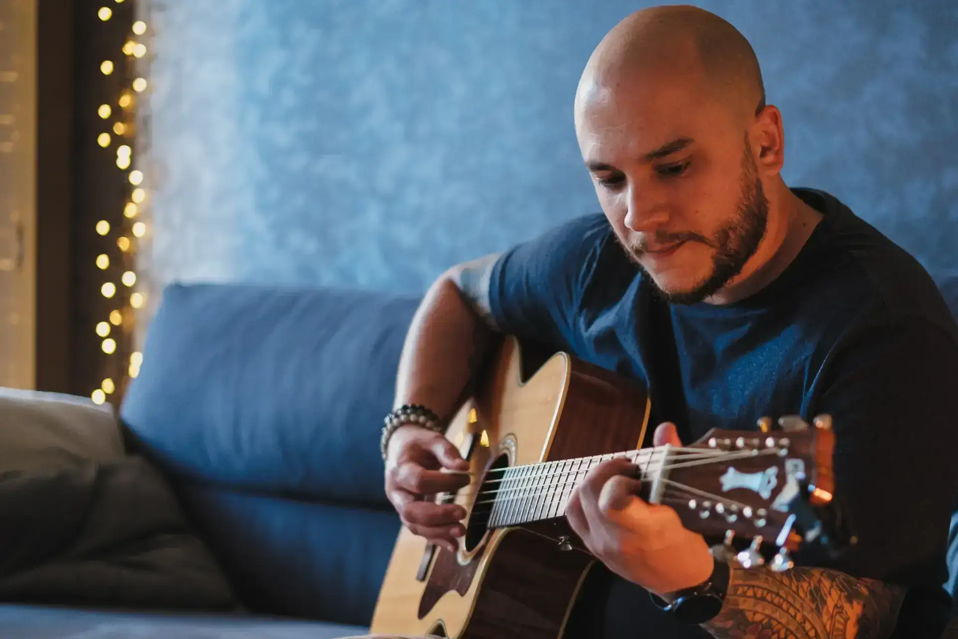Dom jouant de la guitare dans un cadre chaleureux